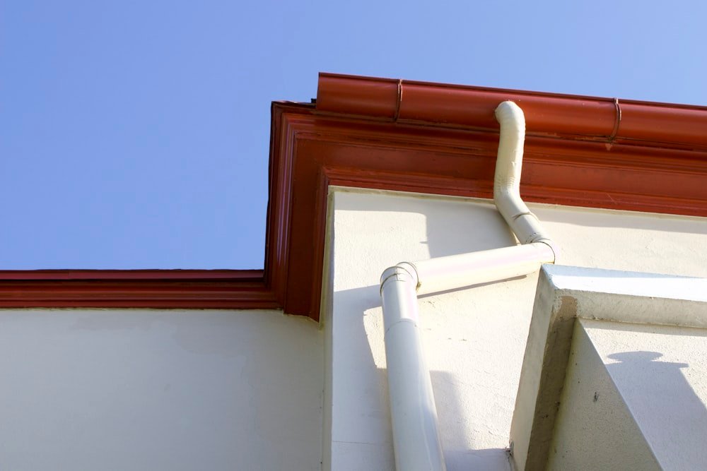 Close-up of a house gutter and downpipe fixed to an exterior wall