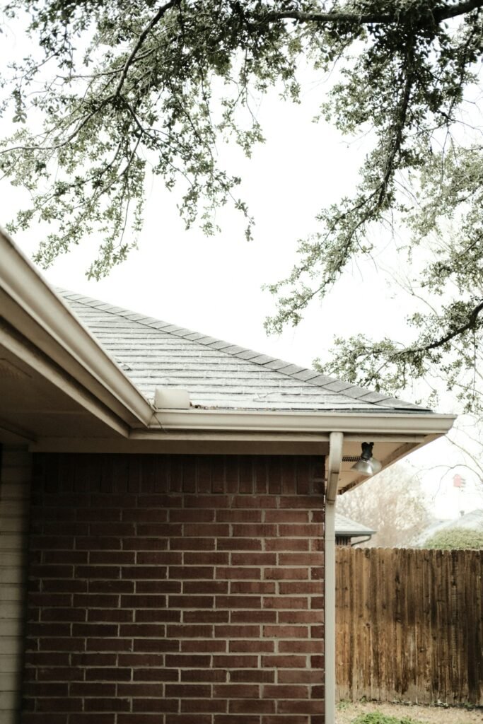 Brick house exterior with a mature tree, in the Grantham area we serve